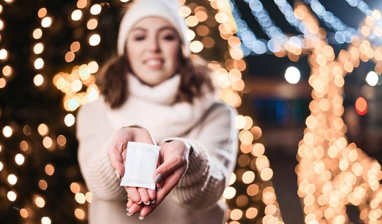 Woman holding a hand warmer outside in the winter