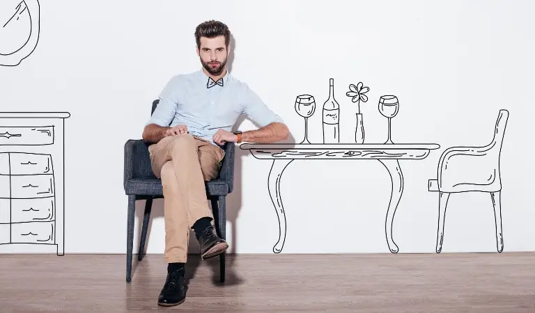 A man sitting in a dining chair with a drawing of furniture for rental property.