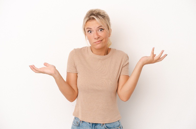 A person shrugging with an uncertain expression against a white background, wondering, "Can my landlord raise my rent?".